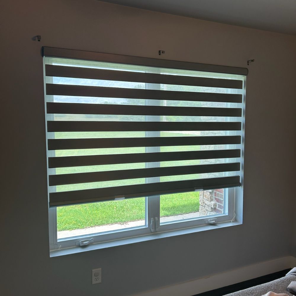 Close-up of layered shades on large residential window with alternating light filtering bands